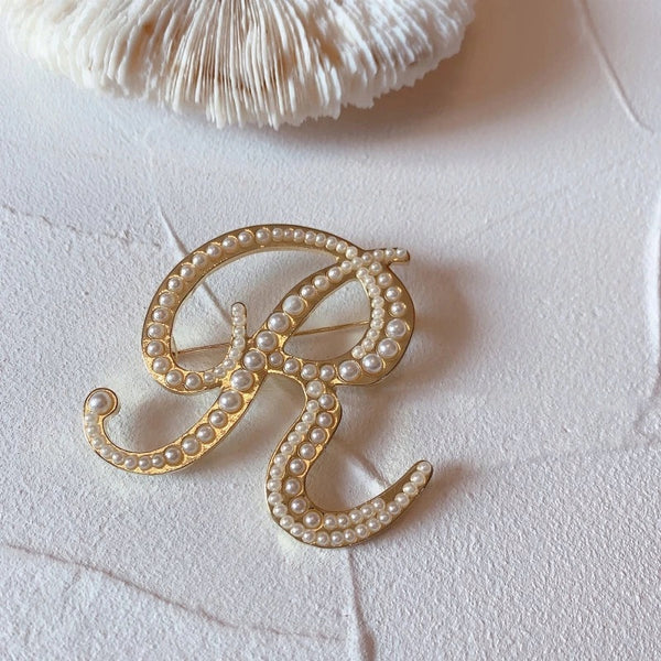 Golden letter R brooch with pearls